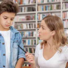 Nauczycielka tłumaczy uczniowi, co oznacza zawieszenie w prawach ucznia. Chłopiec wygląda na smutnego.