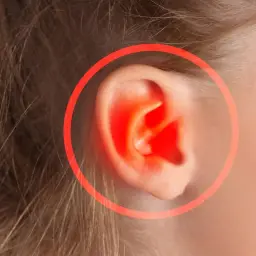 Zapalenie ucha u dziecka. Czy dziecko z zapaleniem ucha może chodzić do przedszkola? Czerwony okrąg podkreśla ból.