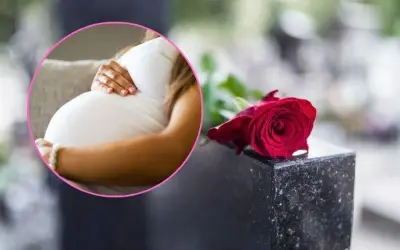 Kobieta w ciąży na pogrzebie, z dłonią na brzuchu, obok czerwonej róży na nagrobku.