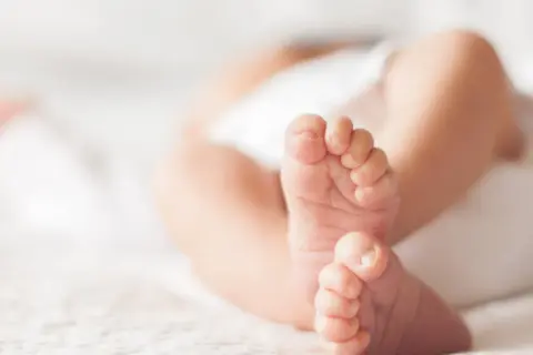 Delikatne, małe stópki niemowlaka, które po kąpieli są mokre i zimne.