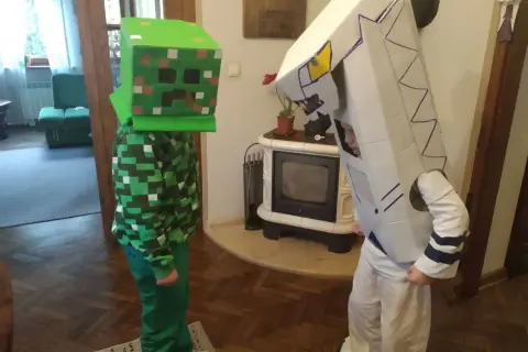 Dzieci w strojach z kartonu: jeden w zielonym kostiumie Creepera z Minecrafta, drugi w białym stroju robota. Świetny przykład, jak zrobić strój z kartonu!