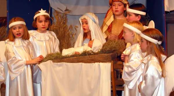 Dzieci odgrywają scenę narodzenia Jezusa, pokazując, skąd się wzięły jasełka.