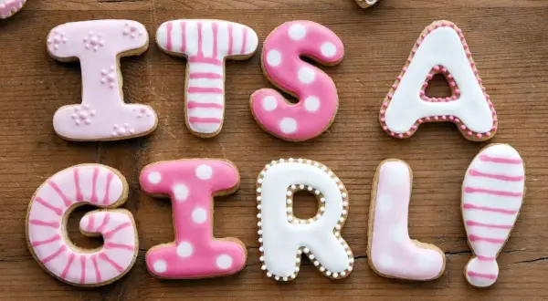 Różowe ciasteczka z literkami układają się w napis "IT'S A GIRL!". Idealne na baby shower, gdy szukamy proste imiona dla dziewczynek.