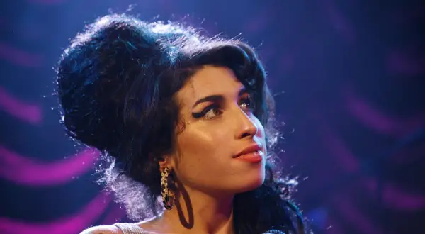 Amy Winehouse, z charakterystyczną fryzurą i makijażem, śpiewa smutne piosenki o mamie.