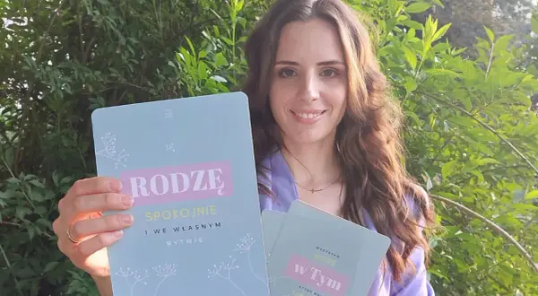 Kobieta trzyma książki z napisem "Rodzę spokojnie" i "Wszystko mogę w tym".