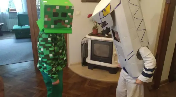 Dzieci w strojach z kartonu: jeden w zielonym kostiumie Creepera z Minecrafta, drugi w białym stroju robota. Świetny przykład, jak zrobić strój z kartonu!