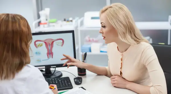 Pacjentka omawia z lekarką anatomię układu rozrodczego, planując zmianę lekarza prowadzącego ciążę.
