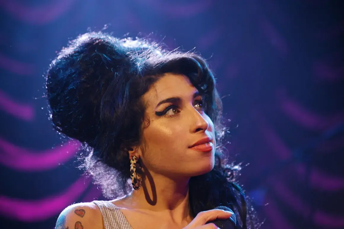 Amy Winehouse, z charakterystyczną fryzurą i makijażem, śpiewa smutne piosenki o mamie.