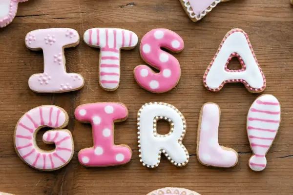 Różowe ciasteczka z literkami układają się w napis "IT'S A GIRL!". Idealne na baby shower, gdy szukamy proste imiona dla dziewczynek.